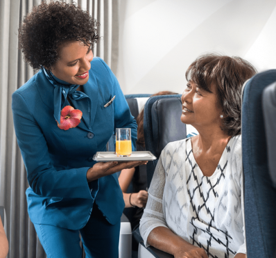 Une hôtesse sert un jus d'orange